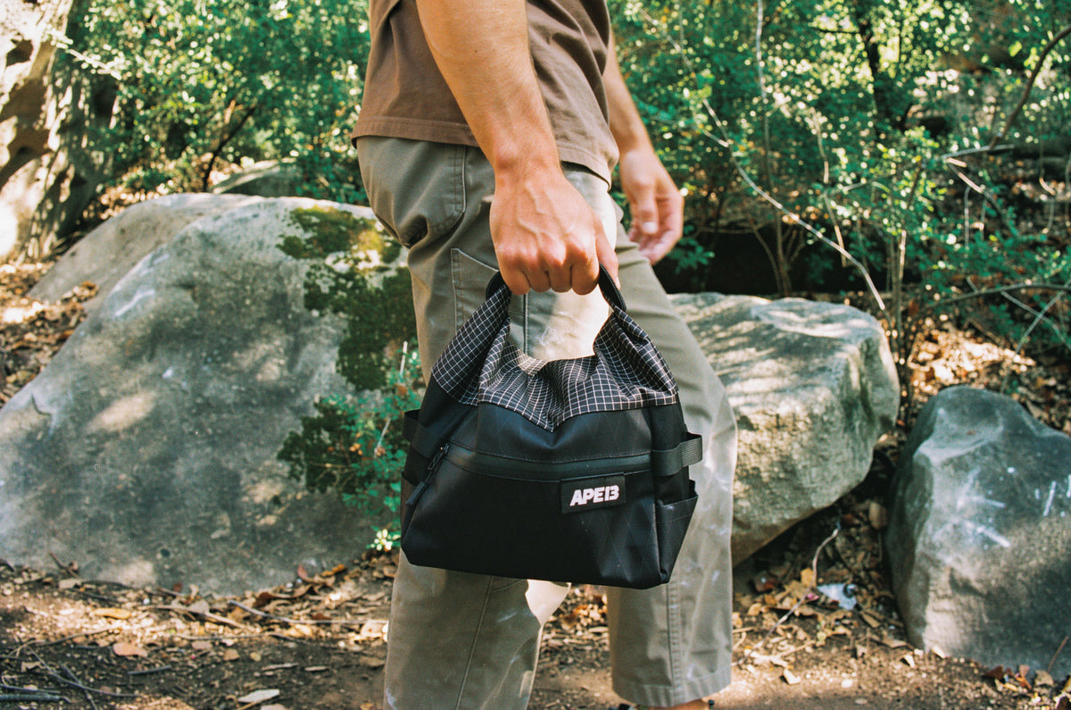 A climber preparing for a bouldering session with APE13 equipment